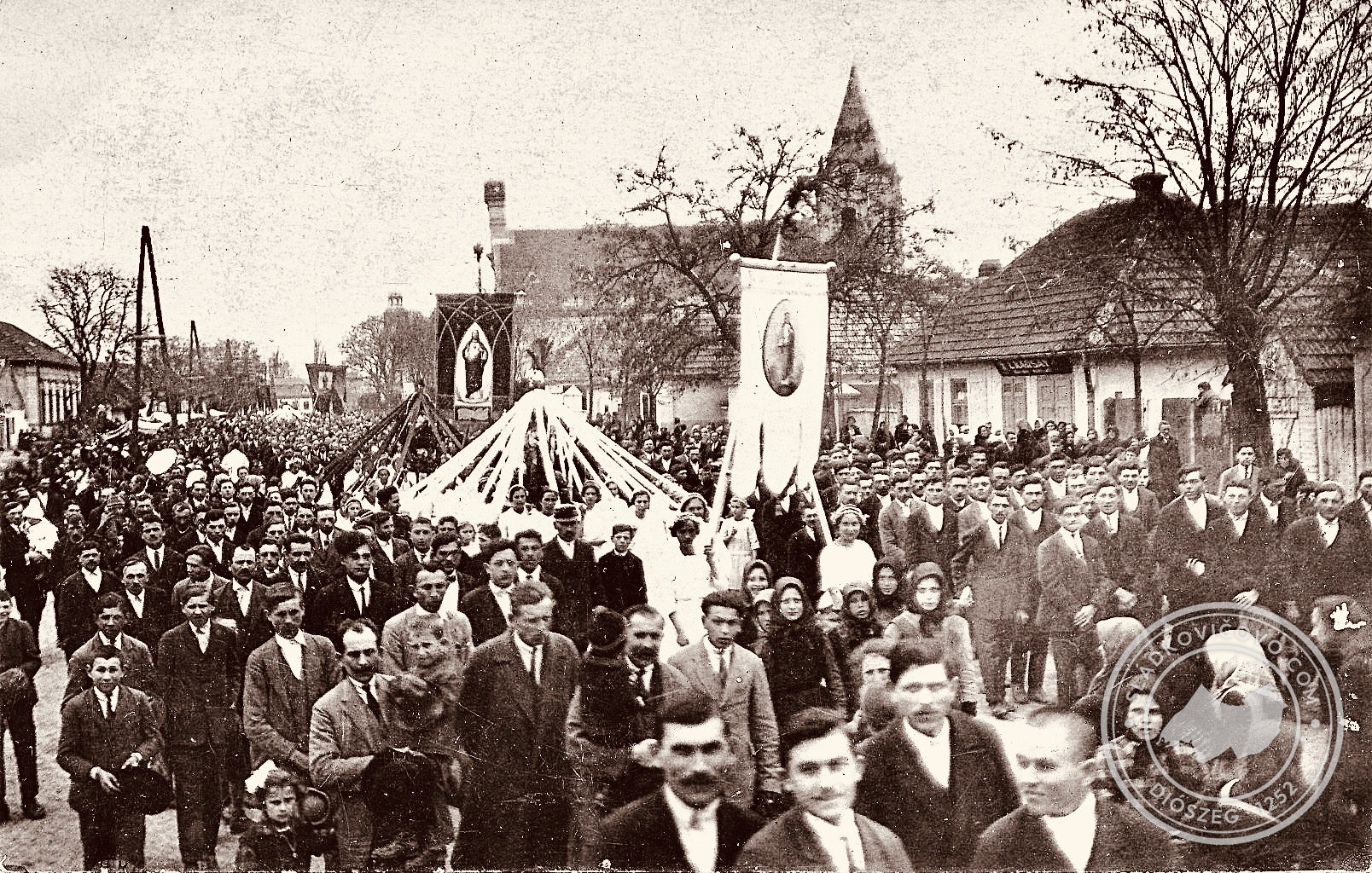 Körmenet halad át a téren valamikor a 20. század harmincas éveiben. A jobb oldali üzlet az egykori Karsay-féle mészárszék.