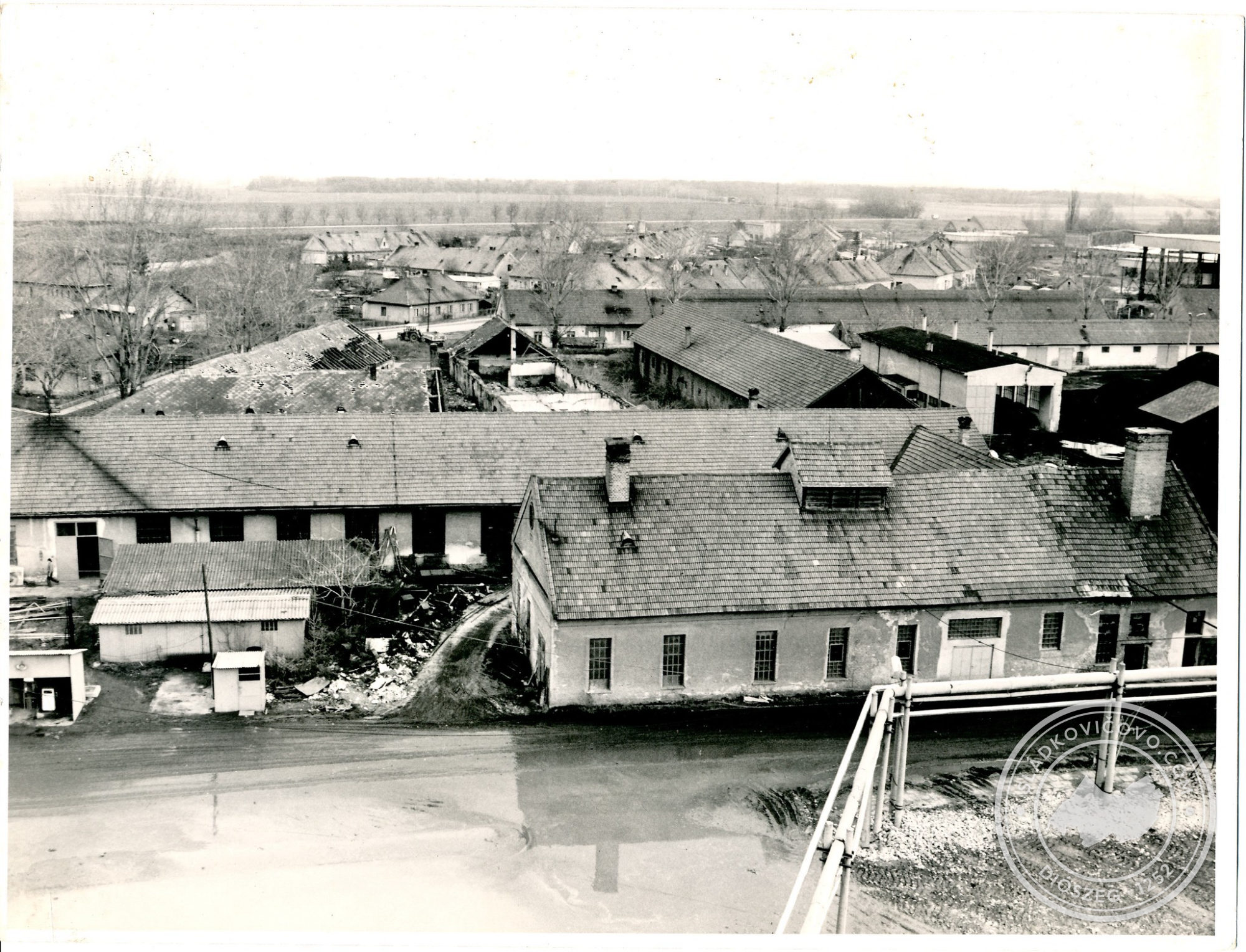 Na fotografii zo 70. rokov 20. storočia z areálu cukrovaru sú v popredí budovy údržbárskej dieľne, za nimi hospodársky dvor (majer), za ním obytné domy "Kasáreň". Na pozadí sa tiahne pás Galantskej cesty so stromoradím.